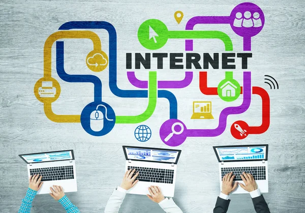 elinde aygıtlarla masada oturan iş adamları 