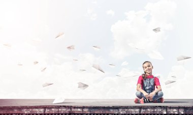 Çatı yapı üzerinde oturan sevimli kız