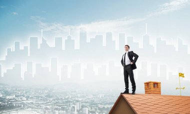 Evin çatısında duran genç işadamı 