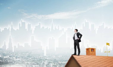 Evin çatısında duran genç işadamı 