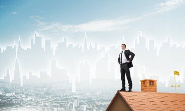 Evin çatısında duran genç işadamı 