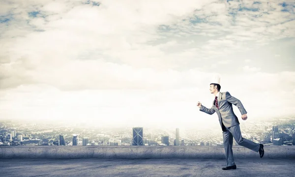 Hombre de negocios guapo corriendo en la azotea del edificio — Foto de Stock