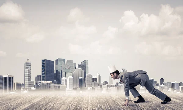 Businessman wearing paper crown running — Stock Photo, Image