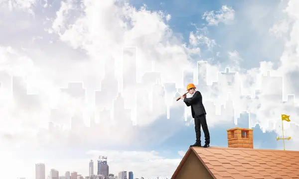 Ο άνθρωπος στέκεται στη στέγη και να αναζητούν σε spyglass — Φωτογραφία Αρχείου