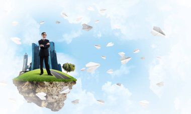 Yeşil yüzen ada üzerinde duran işadamı