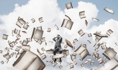 Hayal kırıklığına uğramış işadamı büyük kitap üzerinde oturuyor