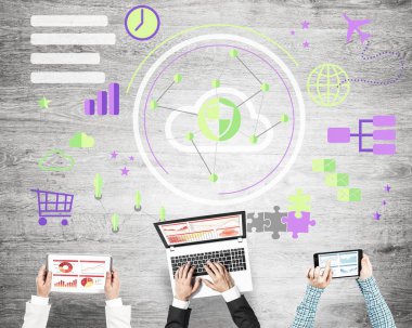 elinde aygıtlarla masada oturan iş adamları 