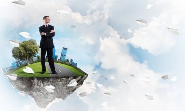 Yeşil yüzen ada üzerinde duran işadamı