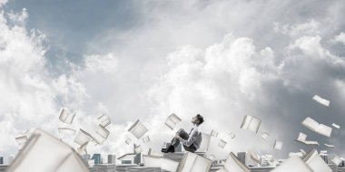 Belgeleri yığını üzerinde oturan işadamı 