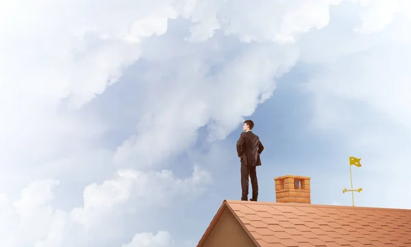 businessman standing on house roof