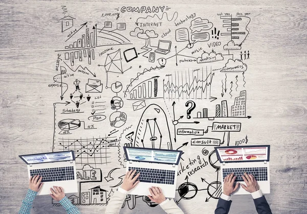 elinde aygıtlarla masada oturan iş adamları 