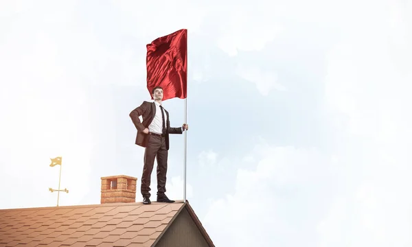 Podnikatel, stojí na střeše domu — Stock fotografie