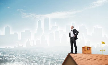 evin çatısında duran işadamı 