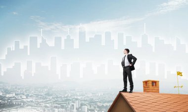 evin çatısında duran işadamı 