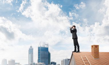 evin çatısında duran işadamı 