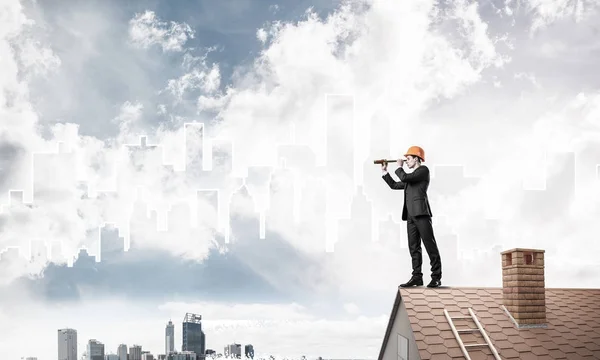 Homem no telhado olhando em spyglass — Fotografia de Stock