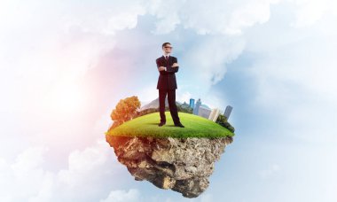 Yeşil yüzen ada üzerinde duran işadamı