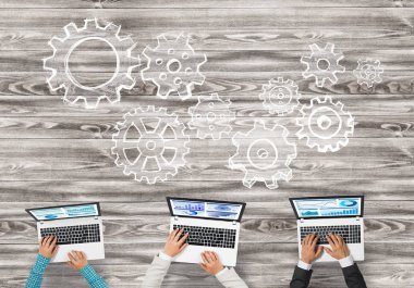 elinde aygıtlarla masada oturan iş adamları 