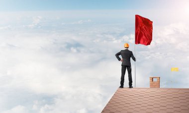 evin çatısında duran işadamı 