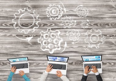 elinde aygıtlarla masada oturan iş adamları 