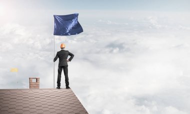 evin çatısında duran işadamı 