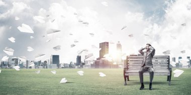 Hayal kırıklığına uğramış işadamı bankta oturan