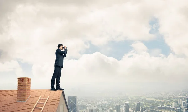 Επιχειρηματίας που στέκεται πάνω σε στέγη σπιτιού — Φωτογραφία Αρχείου