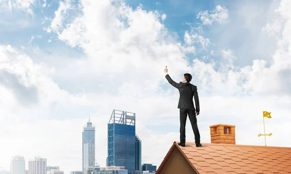 Чоловік стоїть на даху будинку — стокове фото