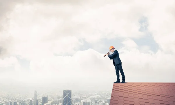 Homem no telhado olhando em spyglass — Fotografia de Stock