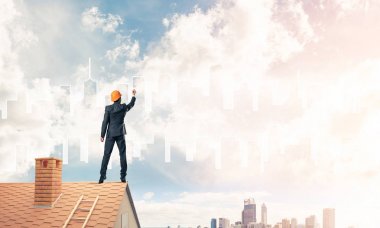 Mühendis adam evin çatısında ayakta 