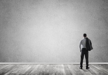 Boş beton odada kendine güvenen zarif iş adamının arka planı