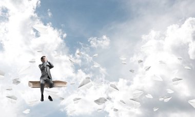 Genç eski kitap üzerinde oturan ve avuç içi gözlerle kapsayan bir işadamı şok