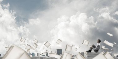 Belgeleri yığını üzerinde oturan işadamı 