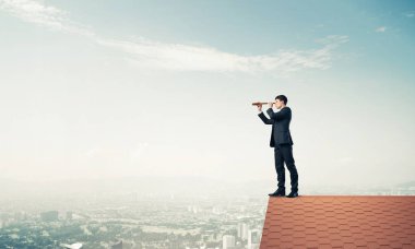evin çatısında duran işadamı 