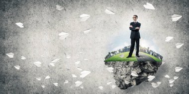 Yeşil yüzen ada üzerinde duran işadamı