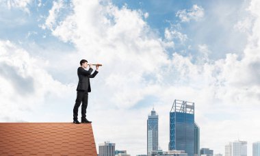 evin çatısında duran işadamı 