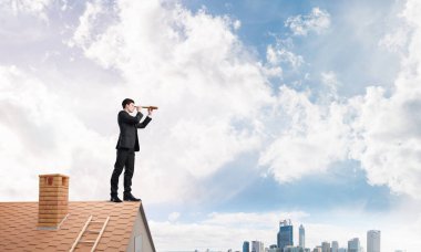 evin çatısında duran işadamı 