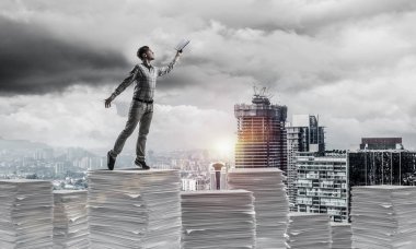Rahat kıyafet ise cityscape belgelerle yığını üzerinde duran ve arka plan üzerinde güneş ışığı el kitabı ile uydurarak adam. Karışık teknik.
