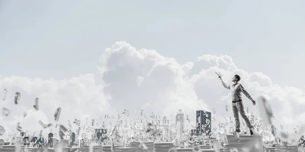背景に文字 Cloudly 空を飛行中に立っている間本を持つ手を追いついてカジュアルな服装での男 ミクスト メディア — ストック写真