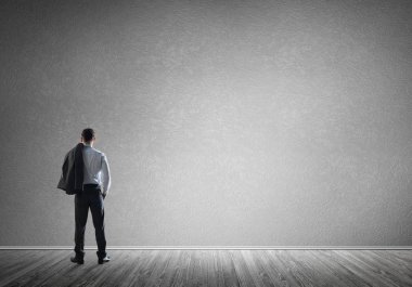 Boş beton odada kendine güvenen zarif iş adamının arka planı