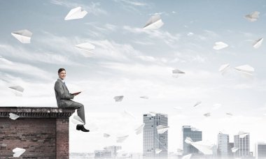 Üst yapı üzerinde oturan genç işadamı