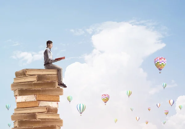 Joven Sorprendido Hombre Sosteniendo Libro Mientras Estaba Sentado Montón Libros — Foto de Stock