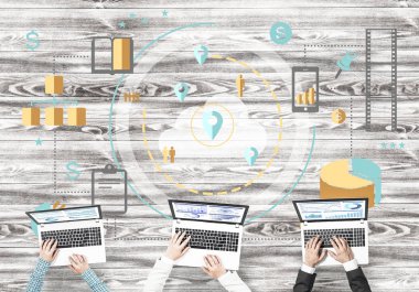 Bir grup ellerinde aygıtlarla üç insan