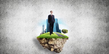 Yeşil yüzen ada üzerinde duran işadamı