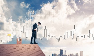 evin çatı kenarında duran işadamı 