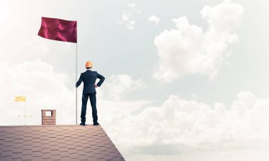 evin çatısında duran işadamı 