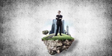 Yeşil yüzen ada üzerinde duran işadamı