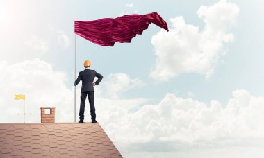 evin çatısında duran işadamı 