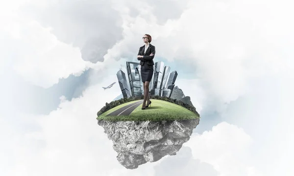 Businesswoman standing on green floating island — Stock Photo, Image