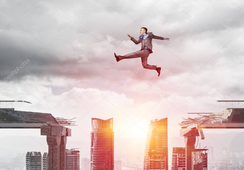 Businessman jumping over gap in concrete bridge as symbol of overcoming challenges with sunlight and cityscape on background, 3D rendering 